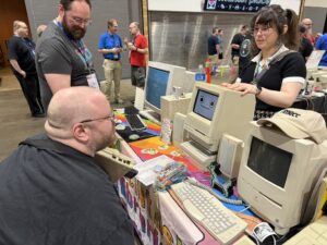 Des visiteurs autour d'une table de Macintosh