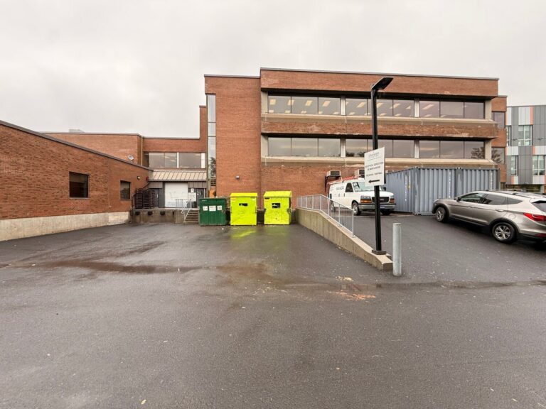 Le quai : porte de chargement et escalier, à côté des conteneurs à déchets.